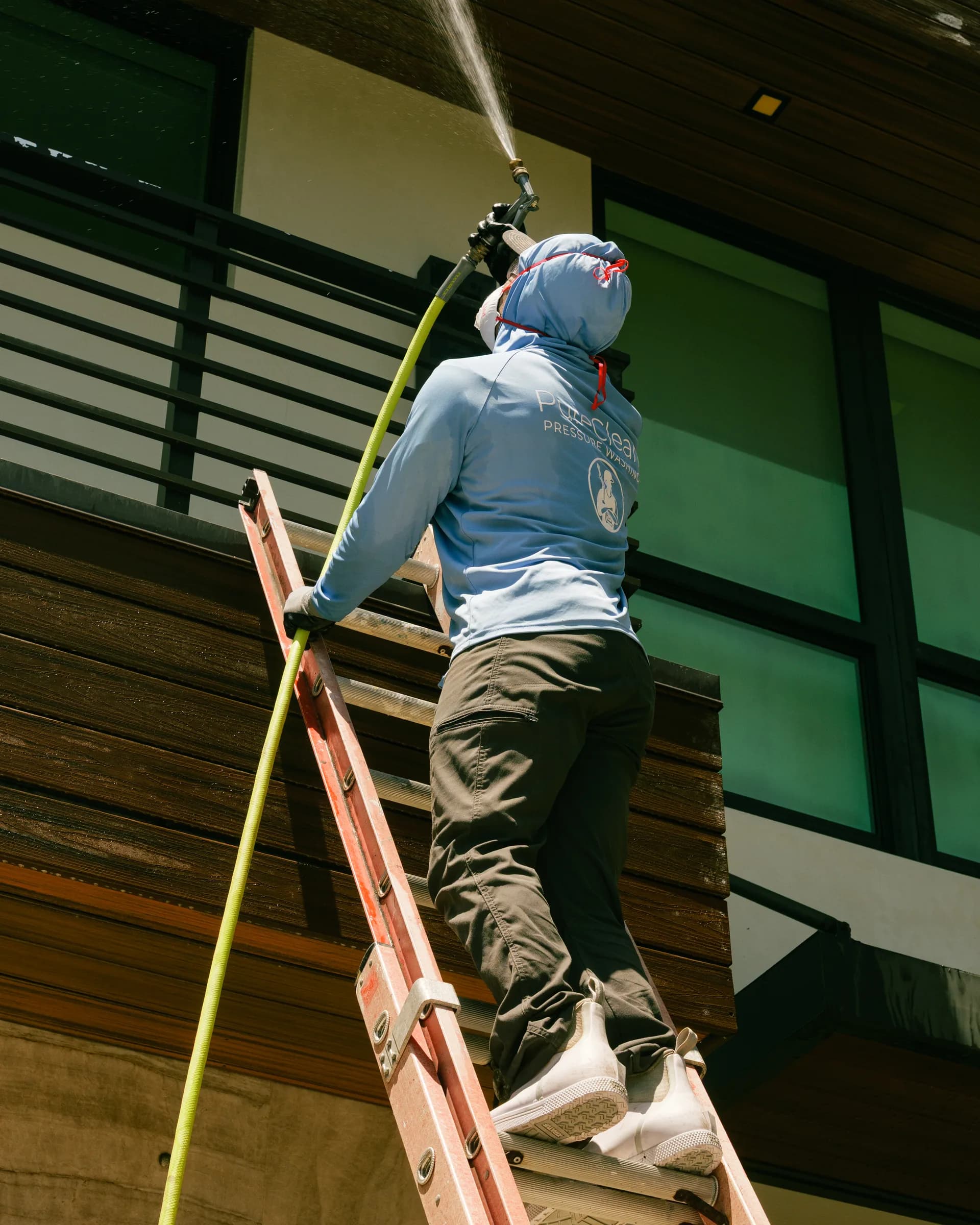 Cleaning upper-floor glass from a ladder
