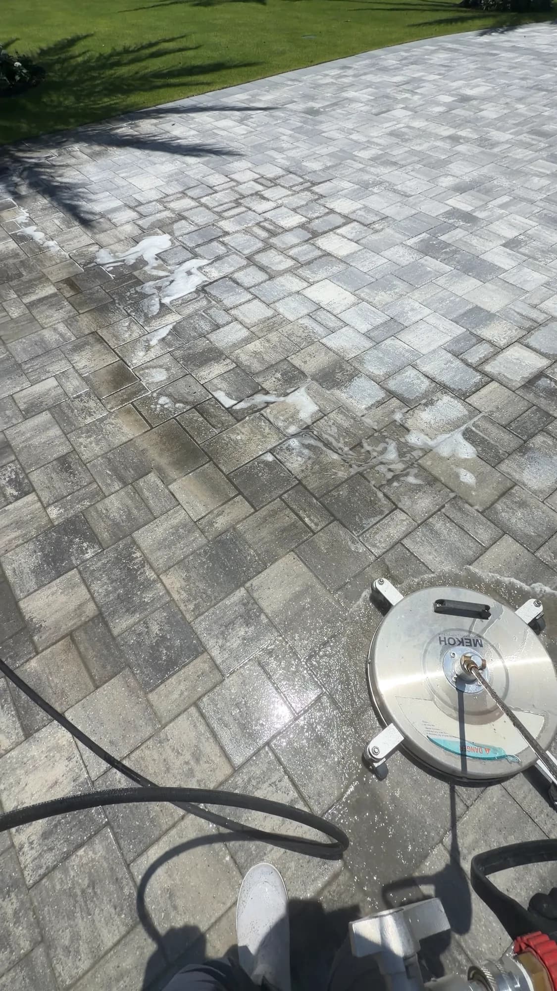 Surface cleaner lifting grime off a paver driveway